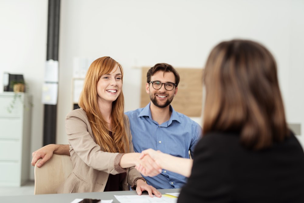 Happy,Young,Couple,Meeting,With,A,Broker,In,Her,Office