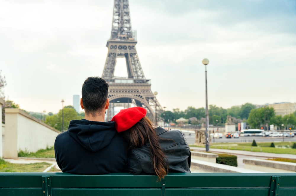 Happy couple exploring Paris streets near iconic landmarks, perfect for Paris honeymoon destinations.