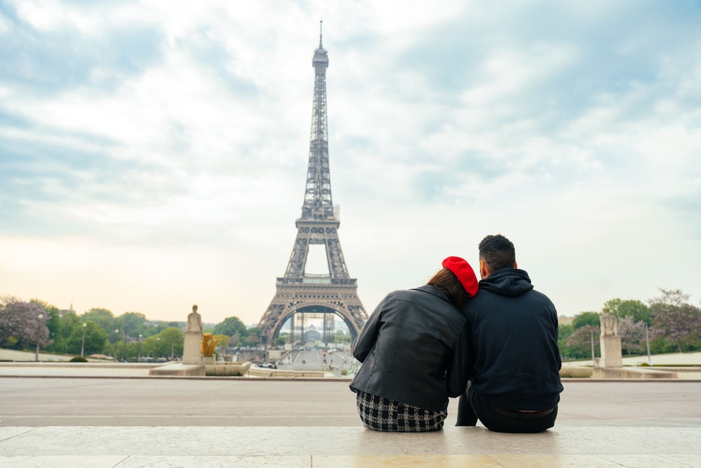 Cheerful couple enjoying romantic moments near the Eiffel Tower, ideal for Paris honeymoon destinations