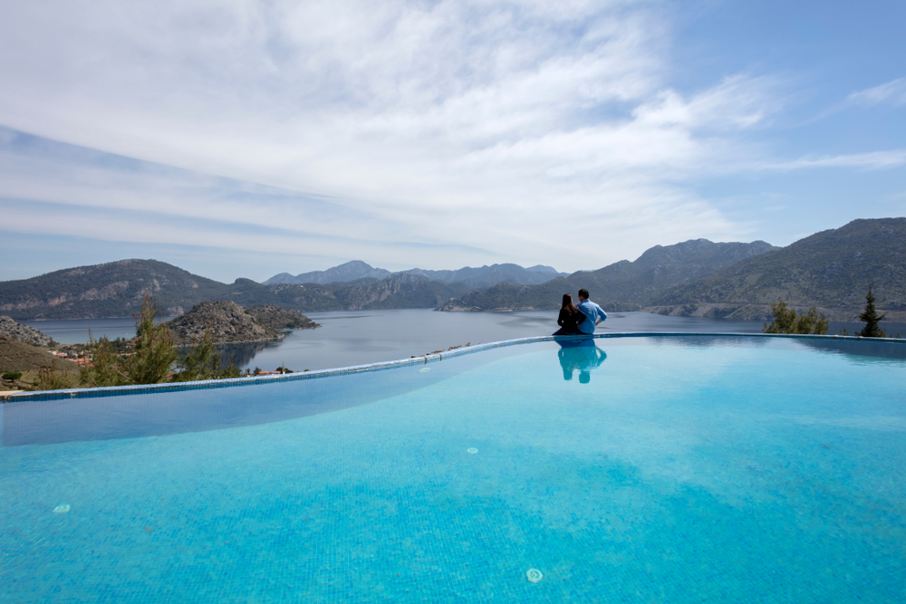 Romantic couple enjoying panoramic views from an infinity pool at one of the best hotels in Kandy for honeymoon