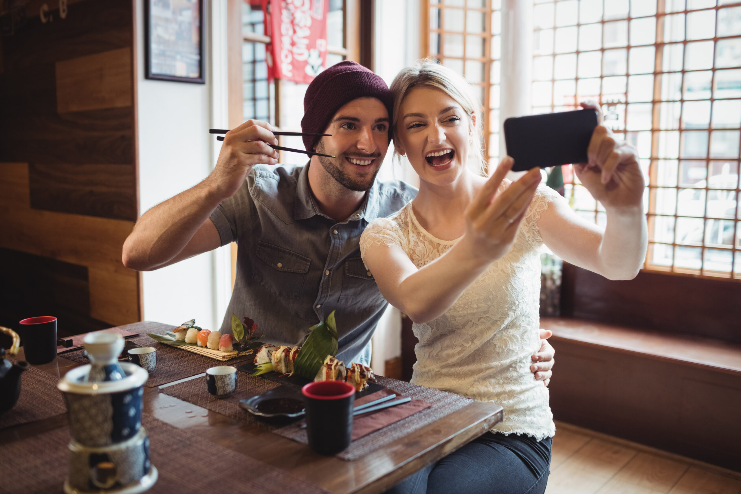Happy couple enjoying sushi on their Japan honeymoon