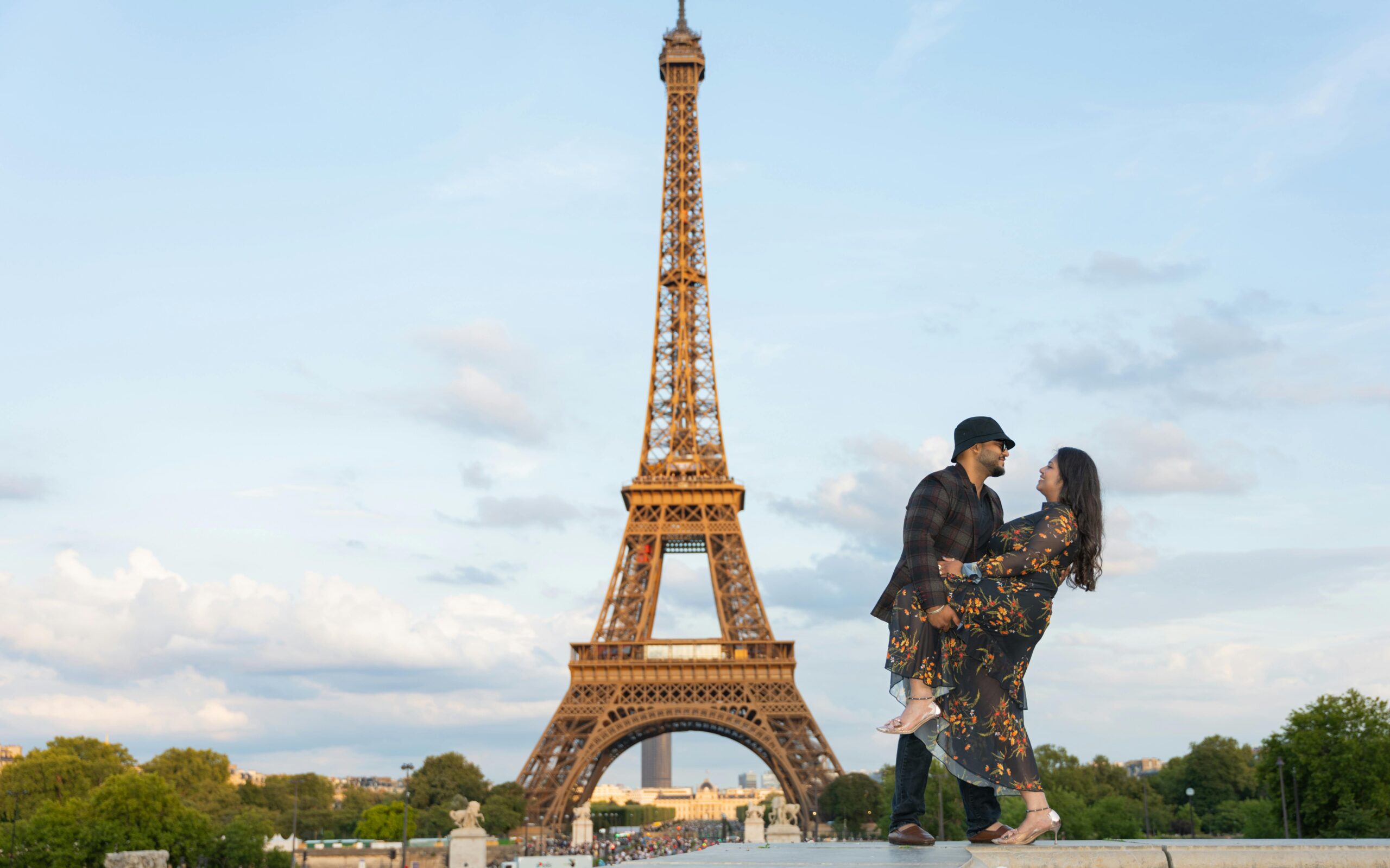 A romantic couple enjoying their honeymoon stay at one of the secret hotels in paris locals love with a stunning view of the Eiffel Tower.