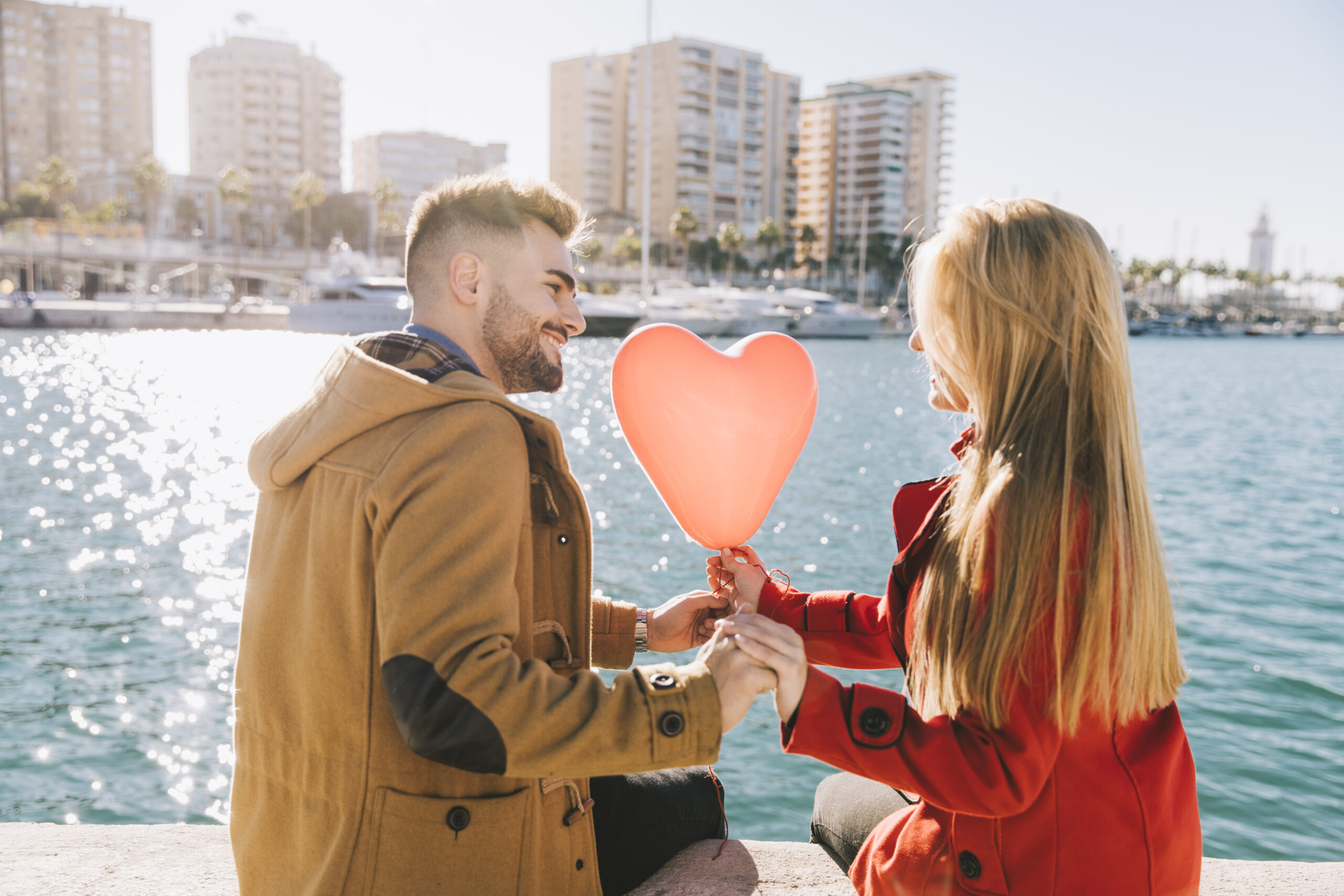 Romantic couple holding a heart balloon by the waterfront, illustrating date ideas Singapore