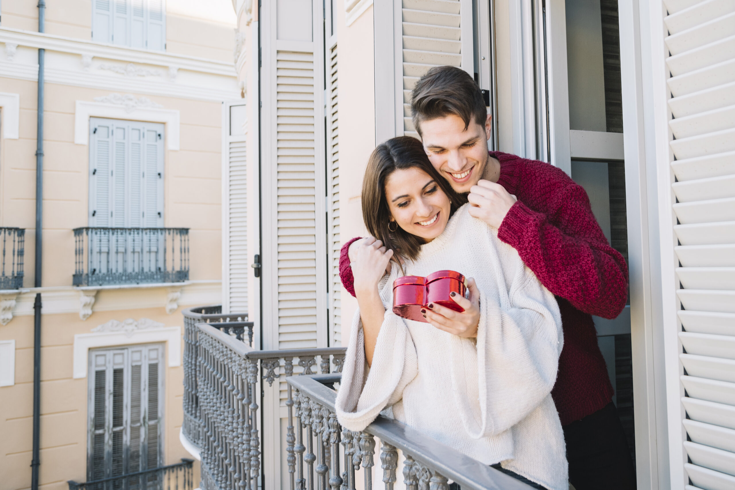 A happy couple enjoying a romantic moment on a private balcony at one of the Secret Hotels in Paris Locals Love