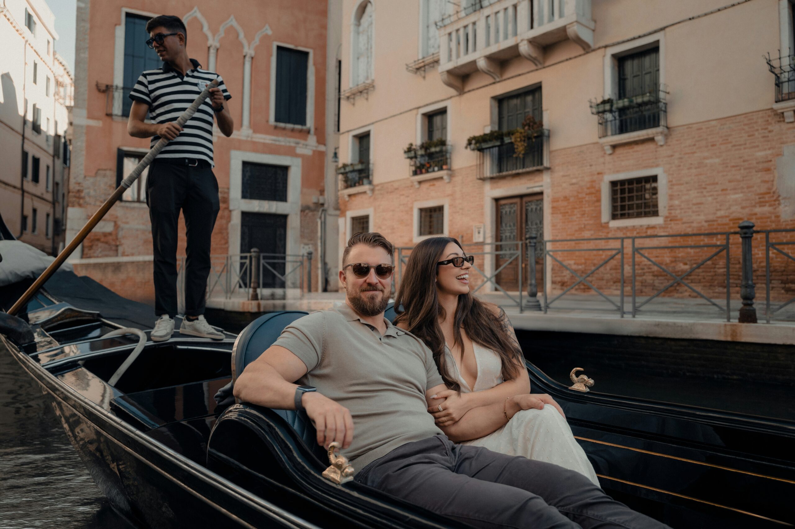 A happy newlywed couple enjoying a romantic gondola ride in Venice, Italy, showcasing the classic experiences offered in top Europe honeymoon packages